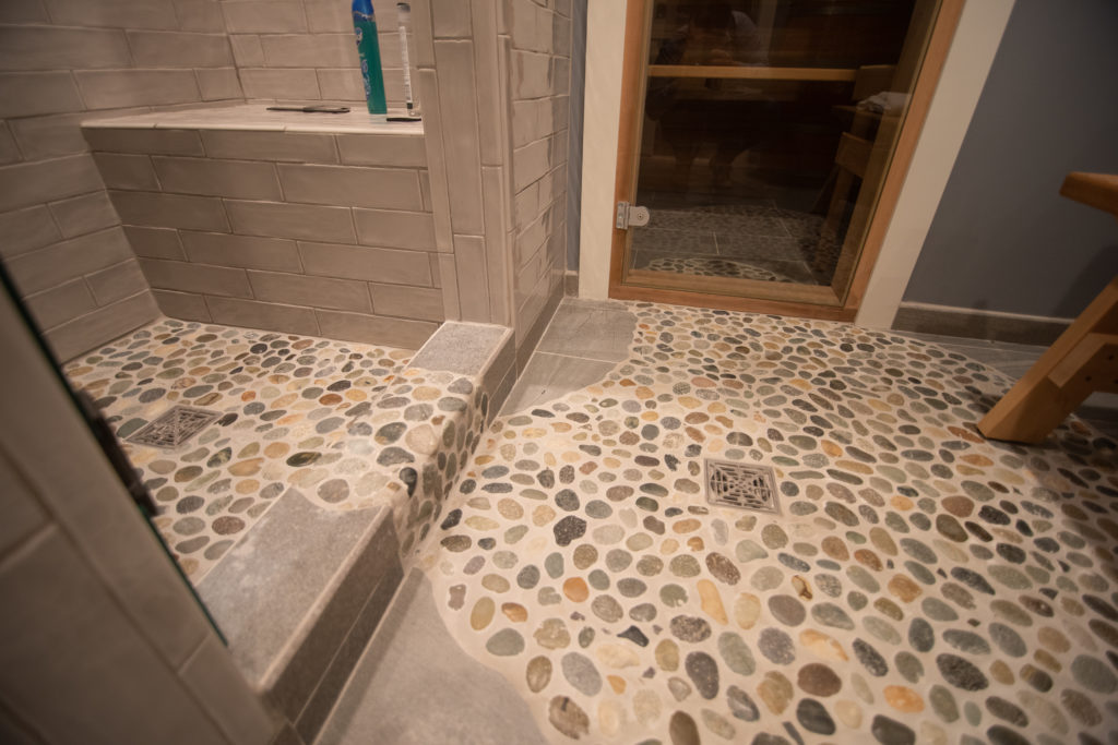 tile flooring in shower from rectangular tiles mixed into rock tiles