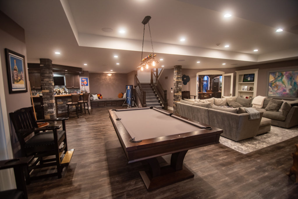 overview of finished basement with warm tones and vinyl plank flooring