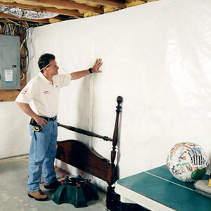 Man installing CleanSpace Basement Wall Vapor Barrier