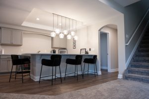 A beautifully remodeled basement with a kitchen.
