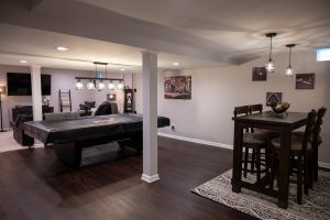 A remodeled basement with an eating area and game table.