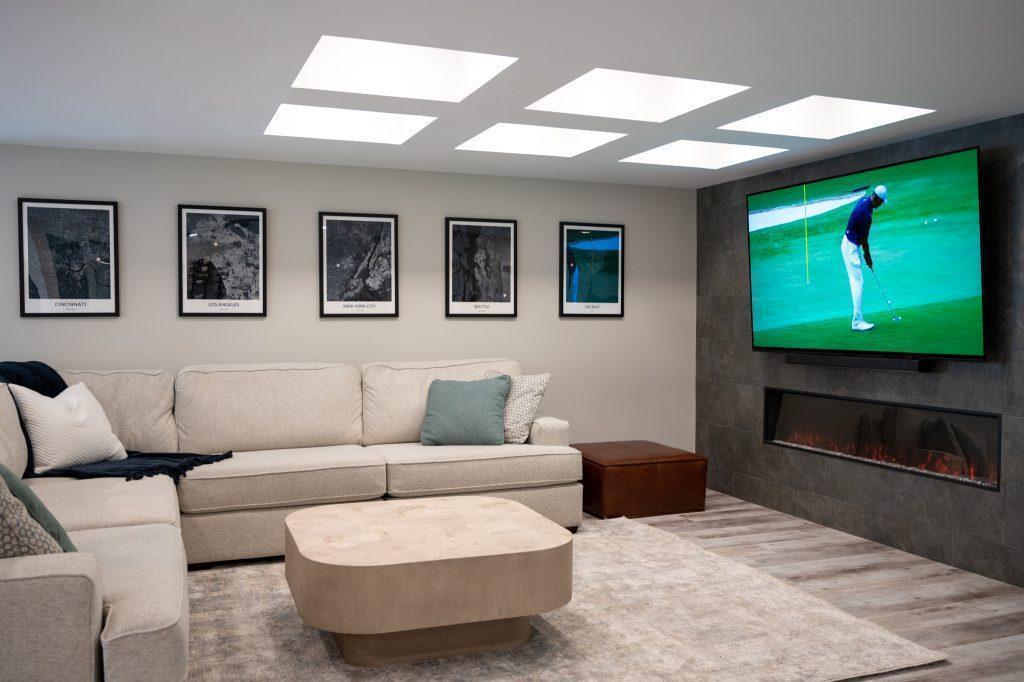 Finished basement living room with coffered ceiling and tile accent wall in Northville, Michigan