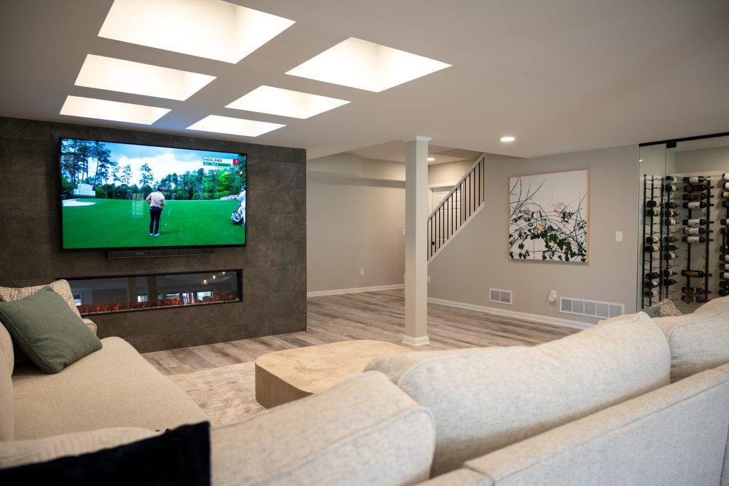 Finished basement living room with coffered ceiling and tile accent wall in Northville, Michigan
