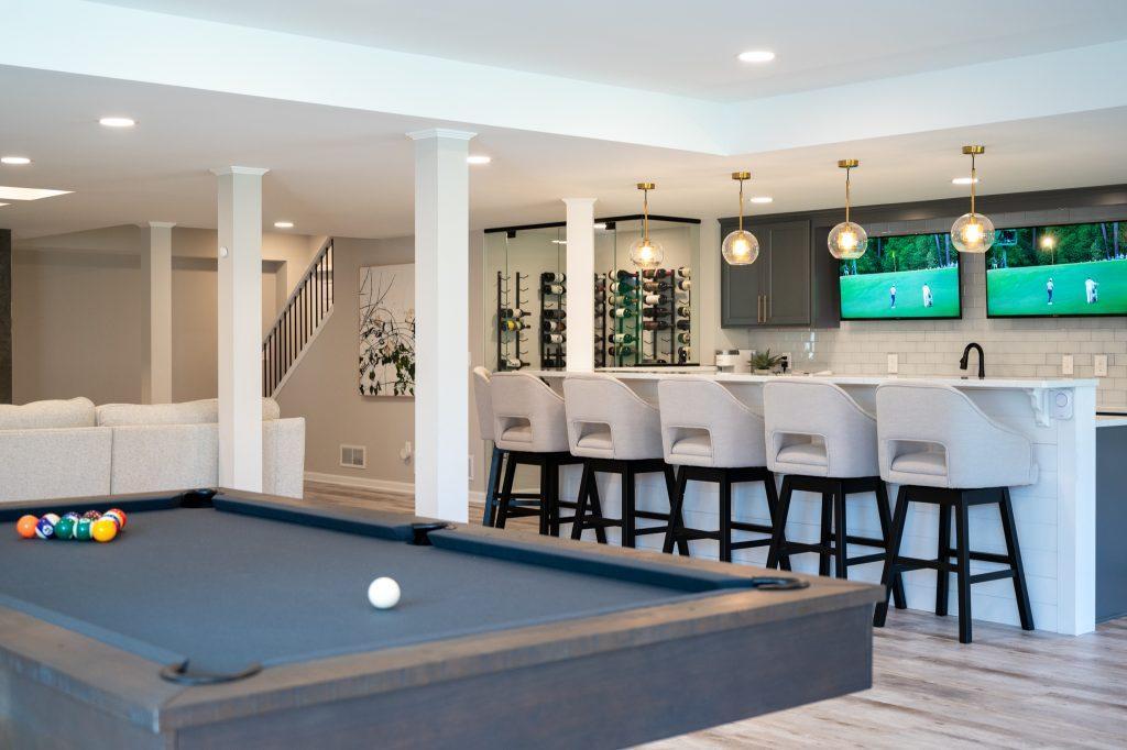 Finished basement pool table with bar and living room view in Northville, Michigan