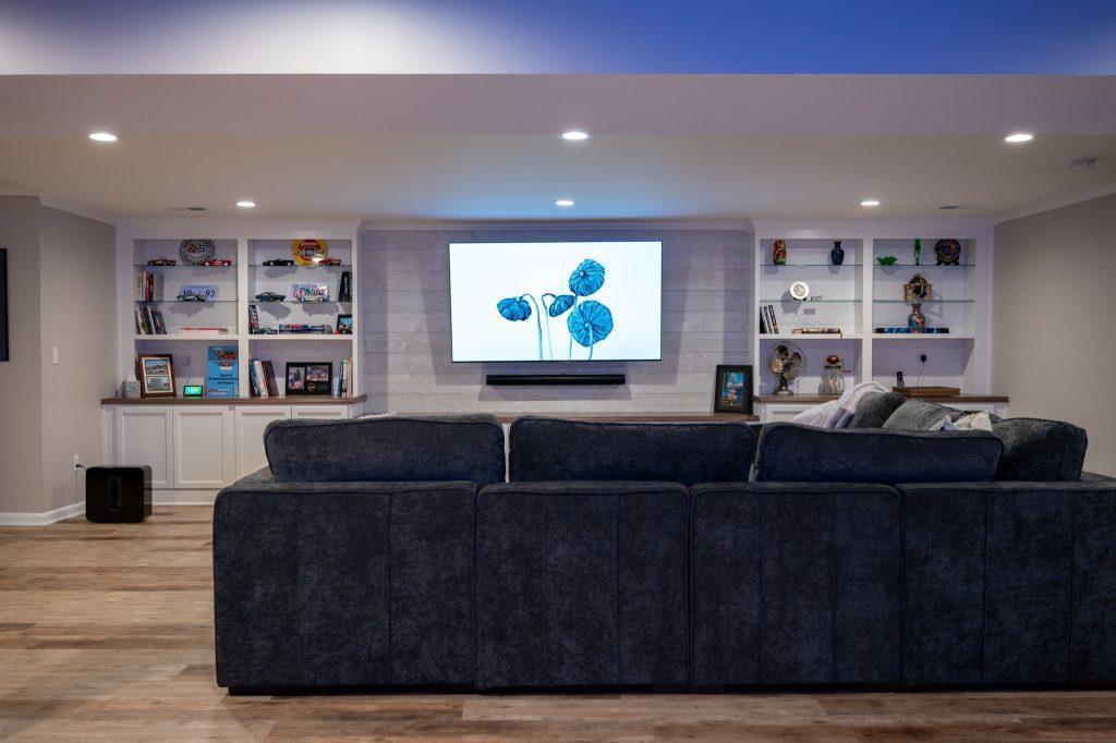 Finished basement living room with white shiplap tv wall and cabinets in Oakland Twp, Michigan