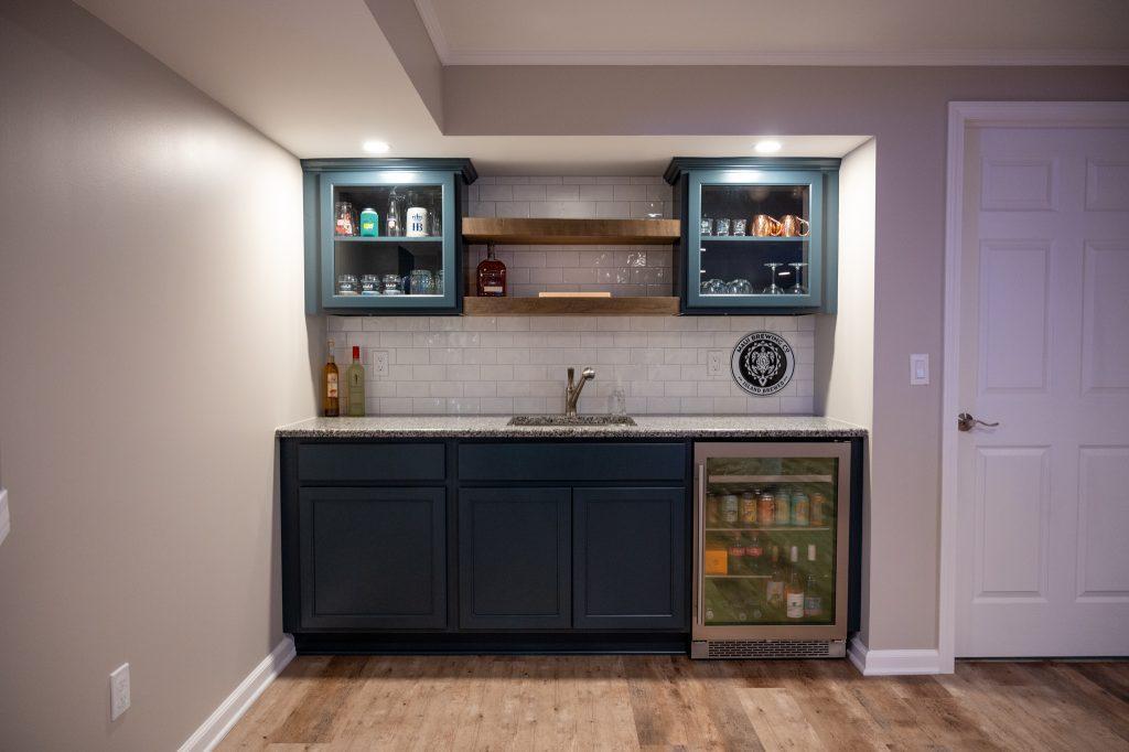 Finished basement wet bar with white backsplash and wood shelving in Oakland Twp., Michigan