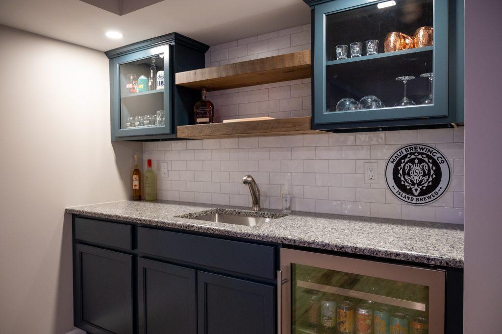 Finished basement wet bar with white backsplash and wood shelving in Oakland Twp., Michigan