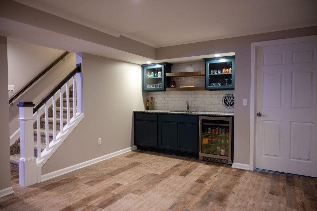 Finished basement wet bar with white backsplash and wood shelving in Oakland Twp., Michigan