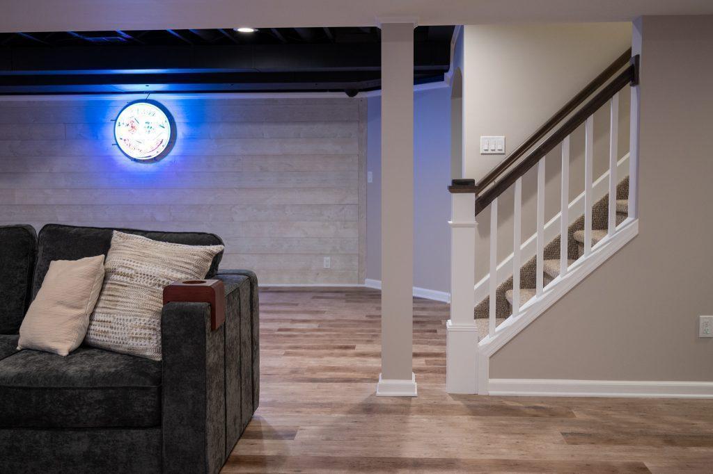Finished basement living room and game area with white shiplap accent wall in Oakland Twp, Michigan