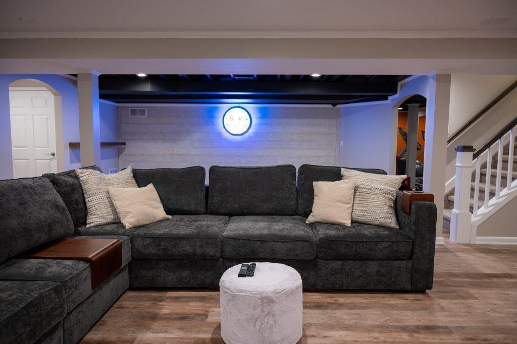 Finished basement living room and game area with white shiplap accent wall in Oakland Twp, Michigan