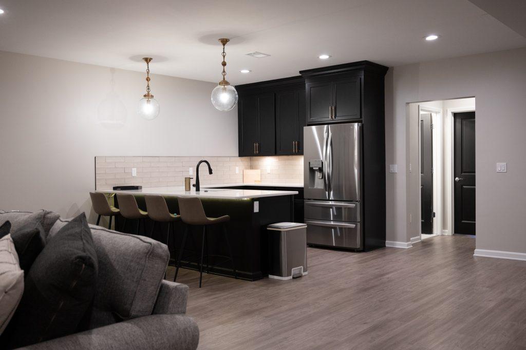 Finished basement bar area with black cabinets in Northville, Michigan