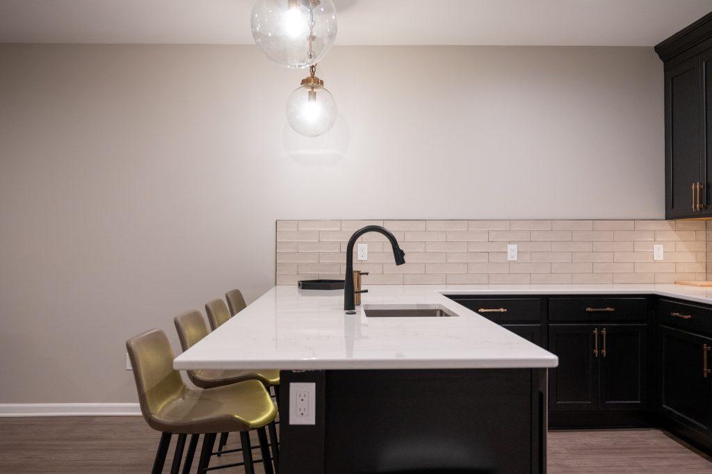 Finished basement bar area with black cabinets in Northville, Michigan