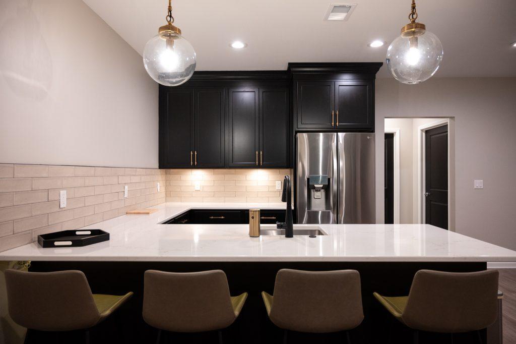 Finished basement bar area with black cabinets in Northville, Michigan