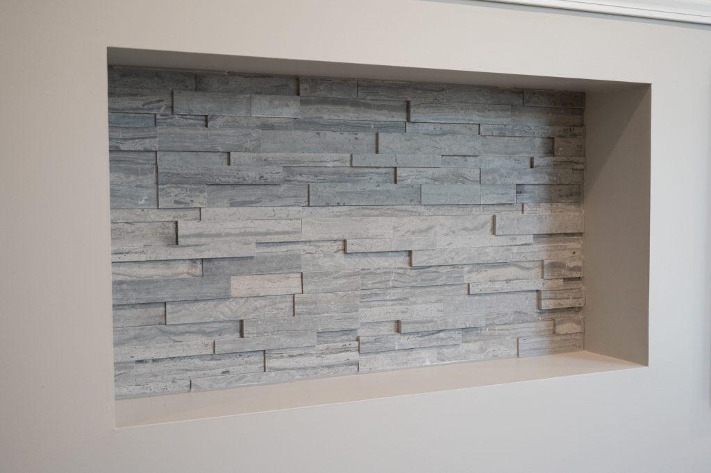 Finished basement living room tv wall ledgestone tile in niche in New Hudson, Michigan