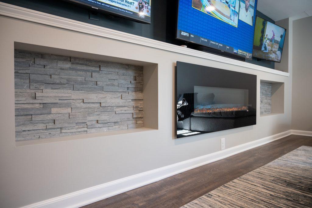 Finished basement living room tv wall with niche tile in New Hudson, Michigan