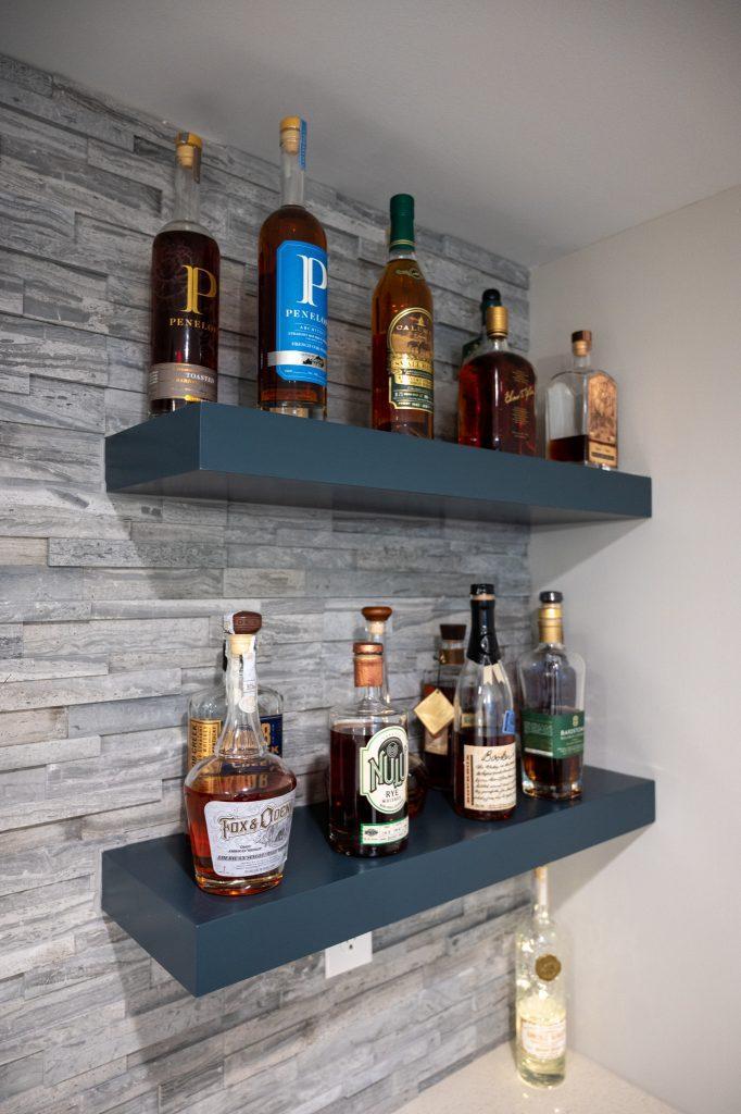 Finished basement shelves with ledgestone backsplash in home bar in New Hudson, Michigan