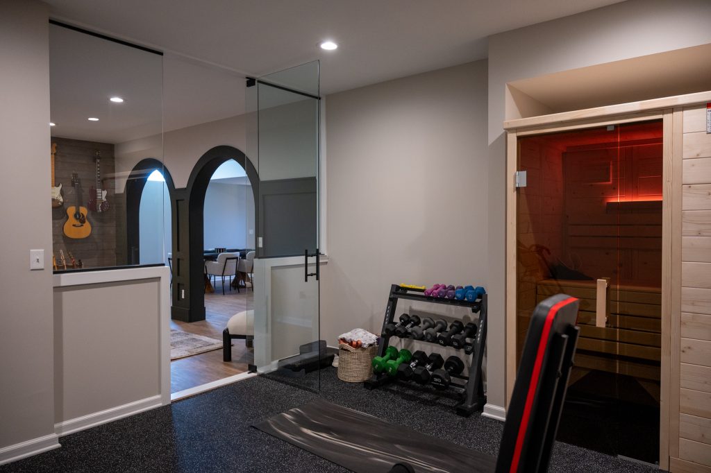 Oakland Township. Basements Plus finished basement showing sauna and workout room with bench and barbell rack.