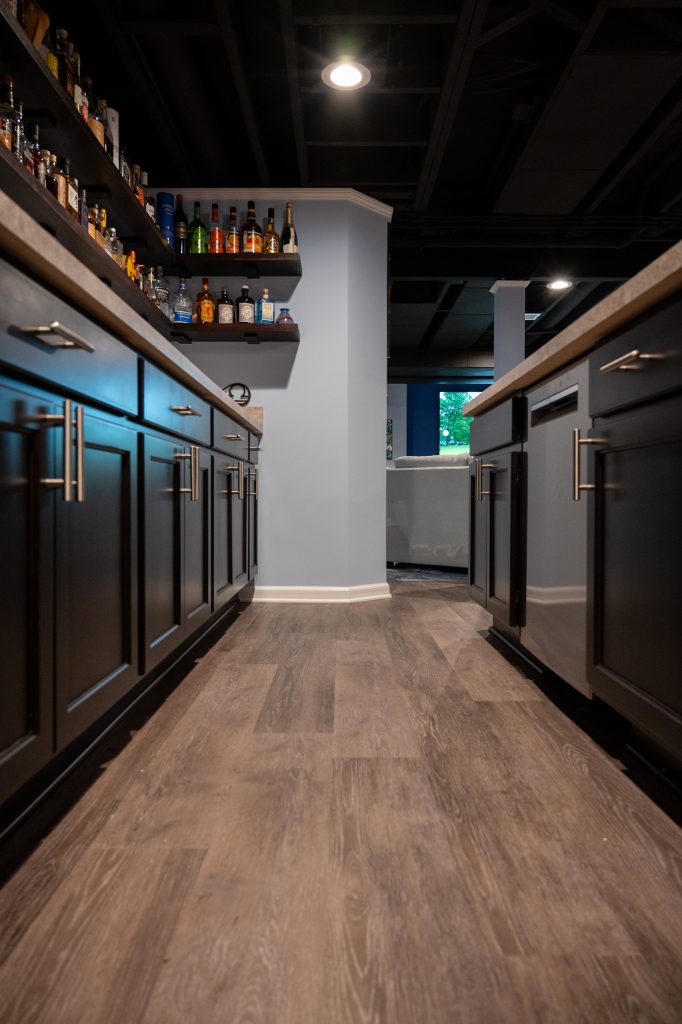 Photo of Basements Plus finished basement showing a view down the walkway of the dark wood bar.