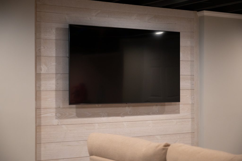Light Accent Wall with Mounted TV in Finished Basement