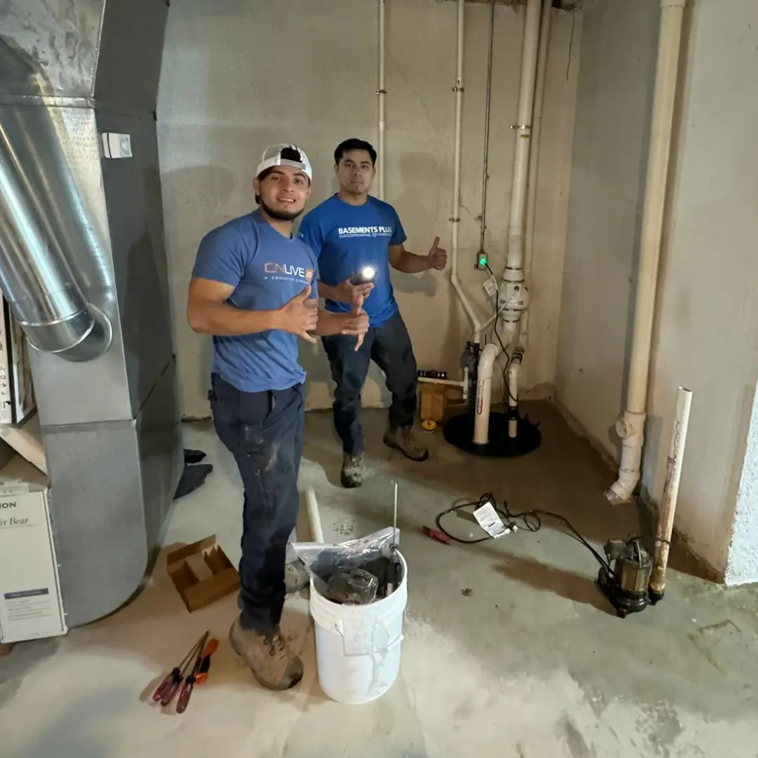 Photo of crew members posing for a photo during a basement waterproofing sump pump install.