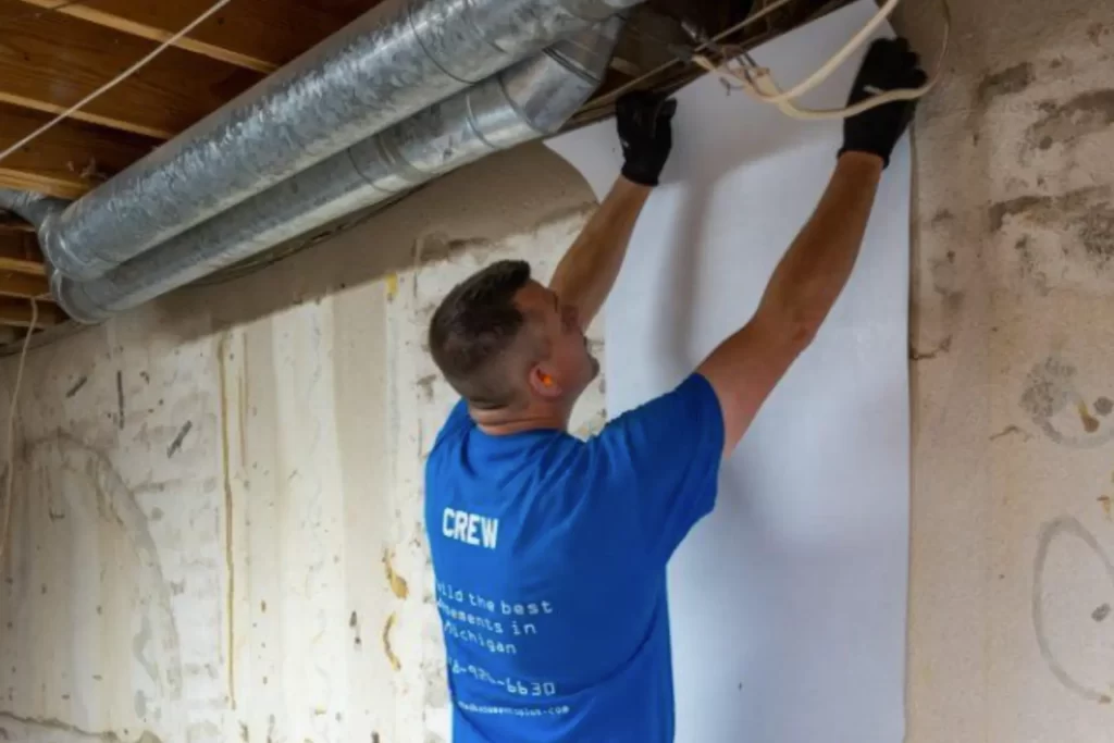 Finished Basements Plus crew member installing a liner in a crawl space.