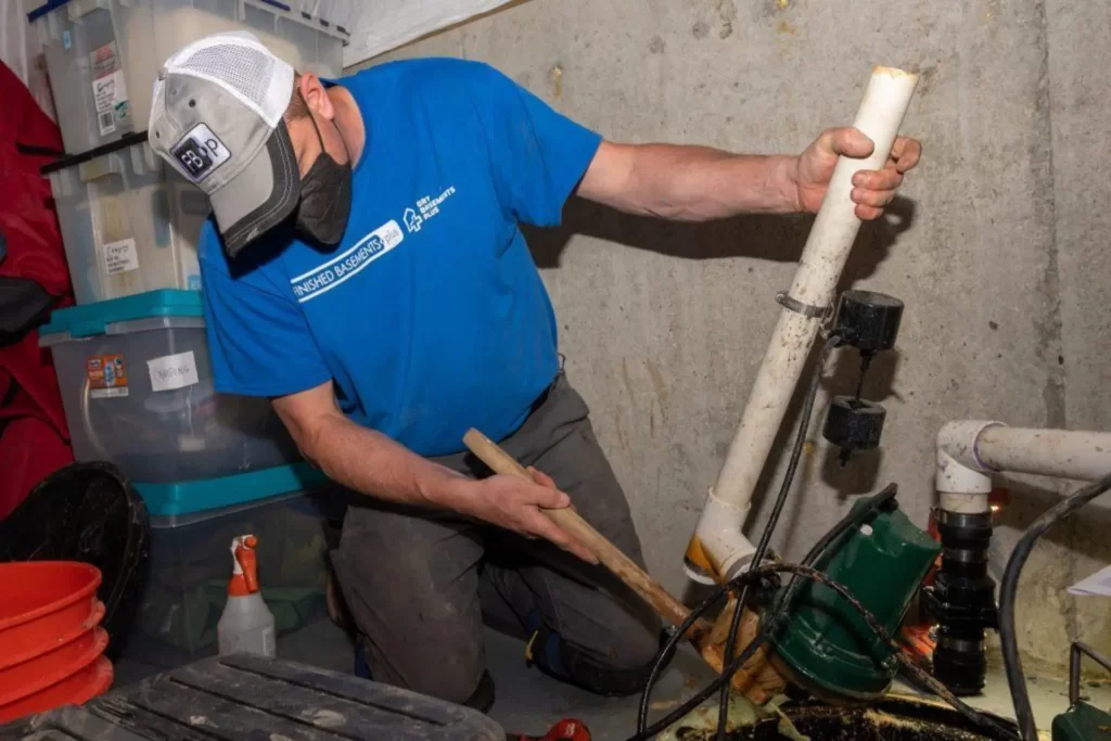 Finished Basements Plus crew member installing a sump pump.