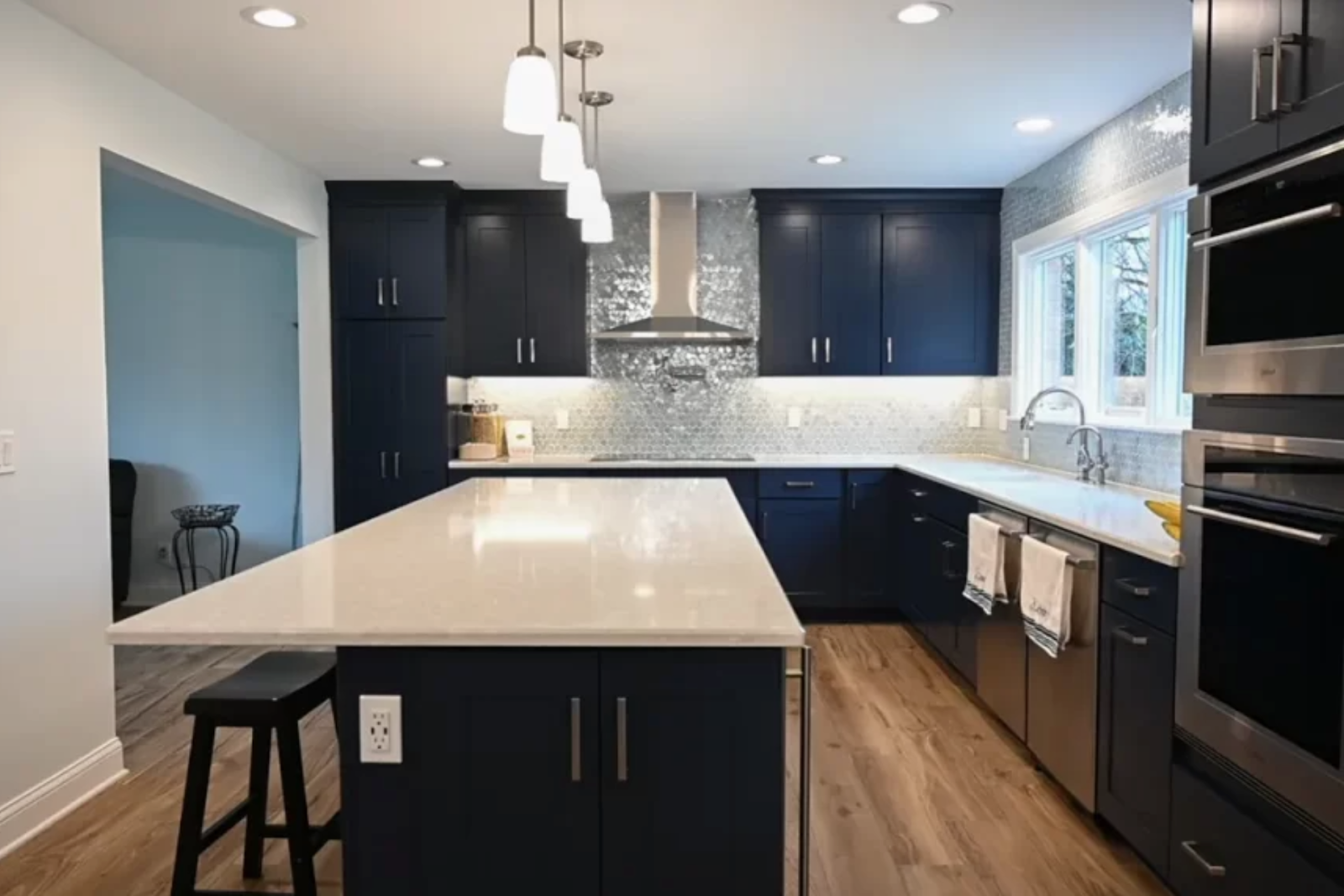 Modern 10x10 kitchen remodel featuring black cabinetry, stainless steel appliances, and a central island.