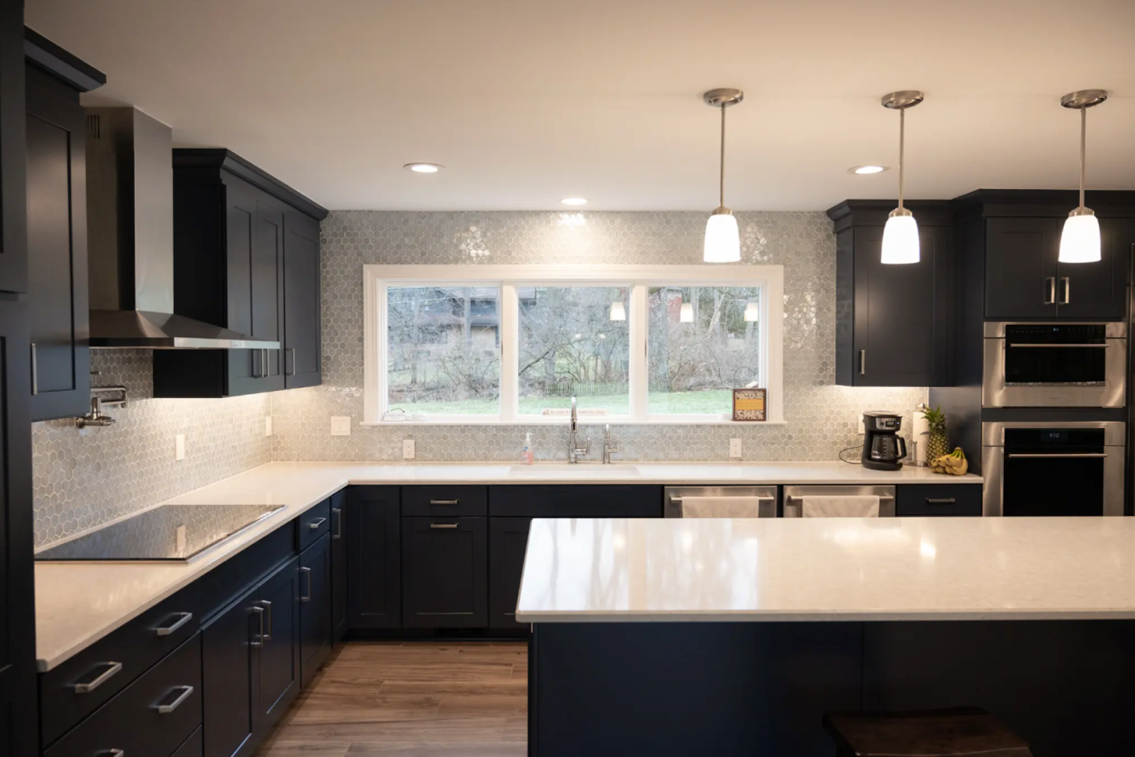 Remodeled kitchen with black cabinets and white countertops showcasing contractor design expertise