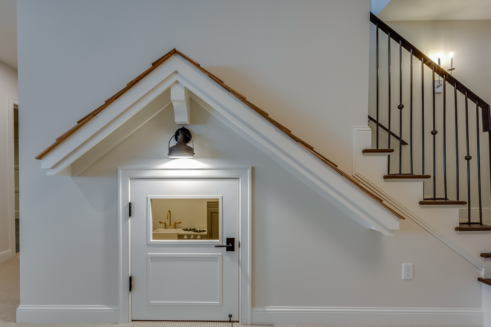 Built-in reading nook with cushions and bookshelves under staircase